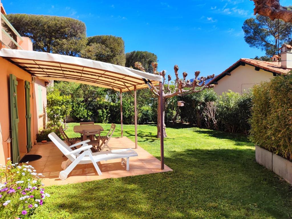 卡西斯Côté Jardin - T2 avec Terrasse Couverte et Jardin的露台设有一张桌子和一把天篷下的椅子