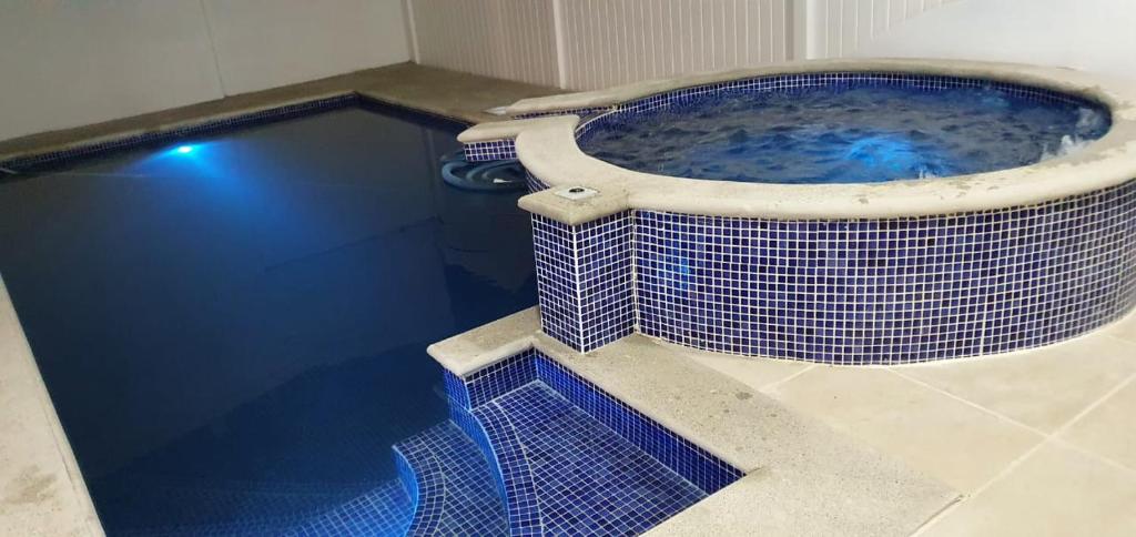 蓬塔雷纳斯Casa de playa con piscina y jacuzzi privado的浴室设有蓝色瓷砖大浴缸