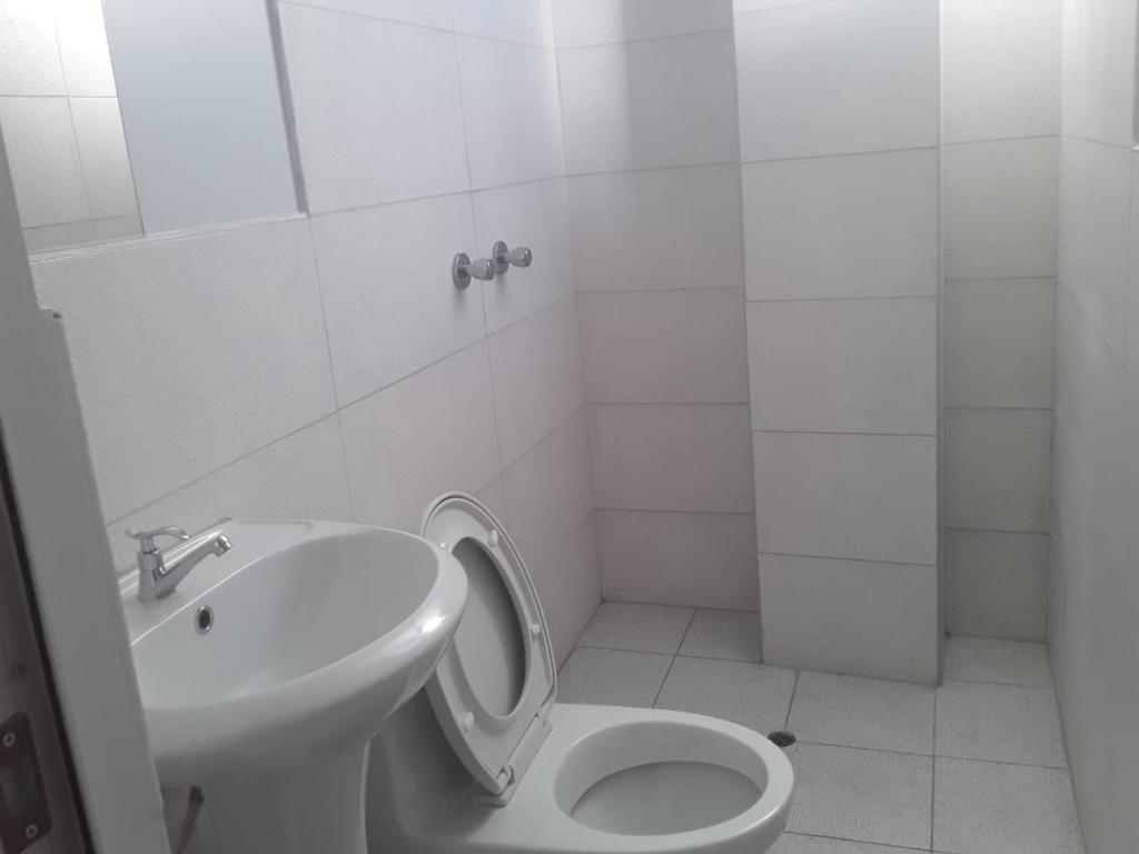 JuliacaRoma Hostal的白色的浴室设有卫生间和水槽。