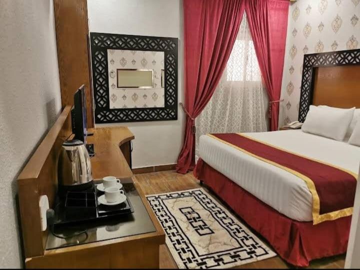 Farasanفندق ساسو سويت للوحدات المفروشه والفندقيه的酒店客房配有一张床和一张书桌及一台电视