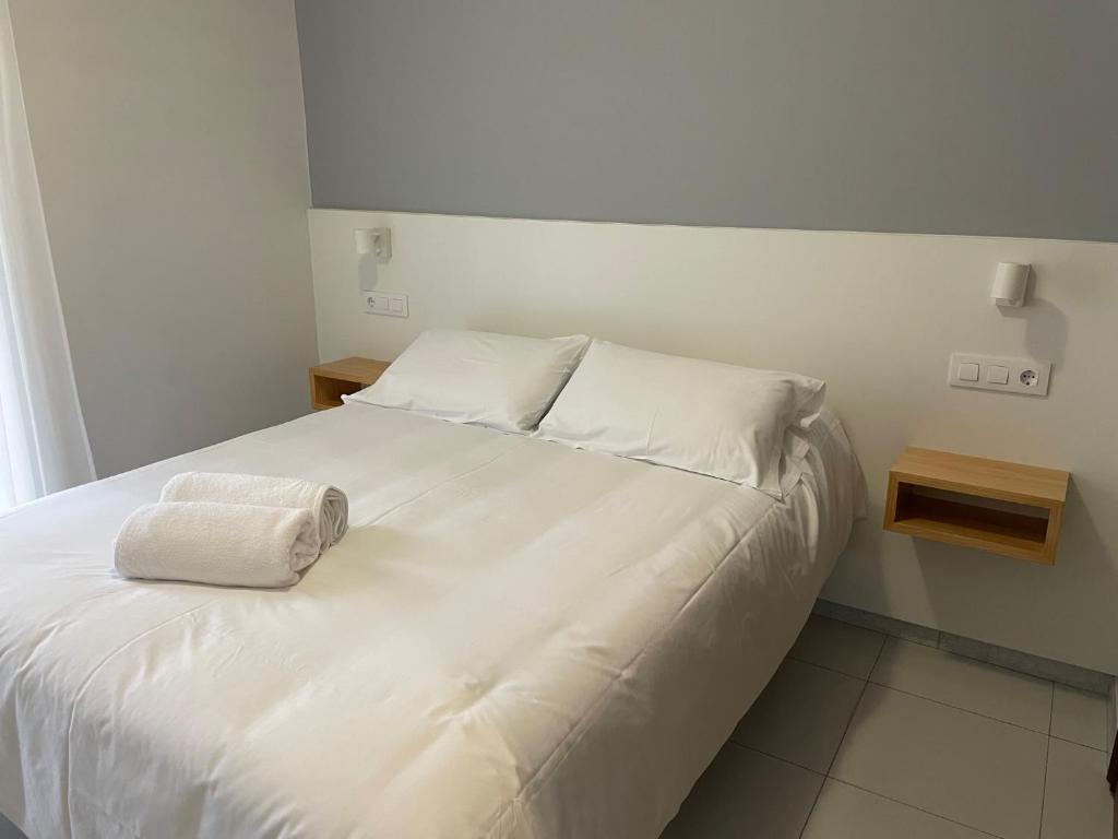桑亨霍委内瑞拉酒店的一张白色的床,上面有两个枕头