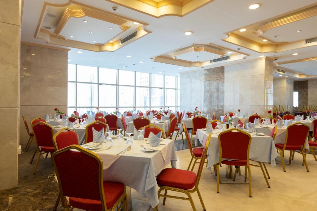 麦加Al Rayyan Towers 4的宴会厅配有白色桌子和红色椅子