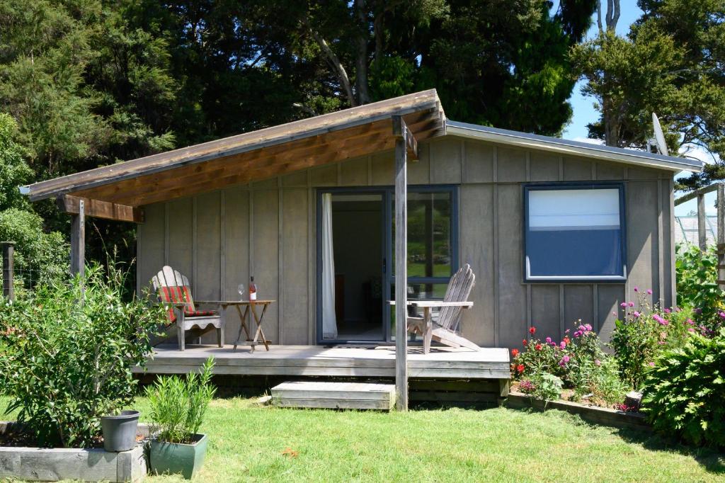 Kaipara FlatsThe Hen House的院子内带桌椅的小小屋