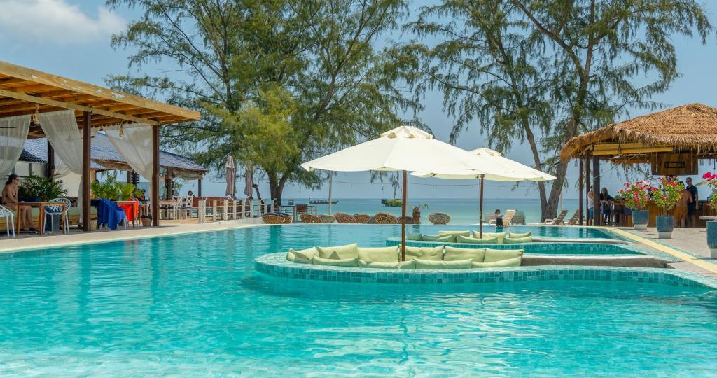 高龙撒冷岛萨拉度假村的一个带椅子和遮阳伞的游泳池