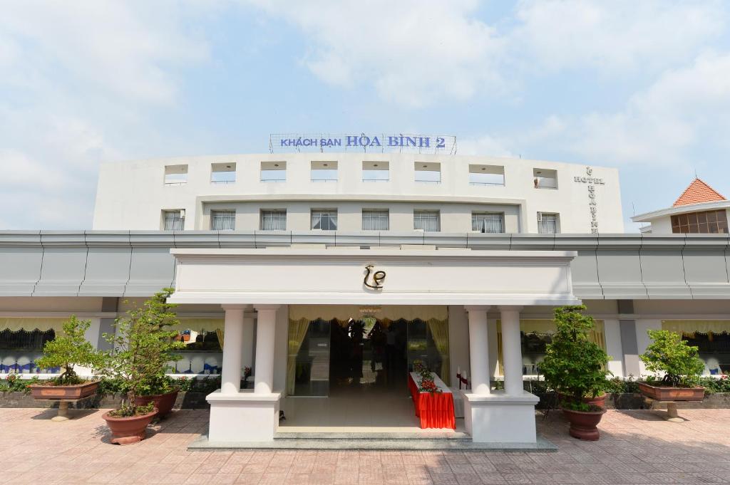 龙川市Nhà Hàng Khách Sạn Hòa Bình 2的前面有商店的白色建筑