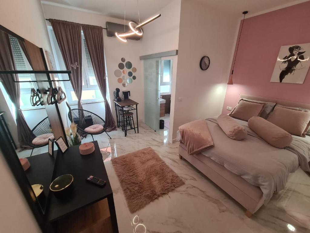 扎达尔Premium class Room的一间卧室配有一张床和粉红色的墙壁
