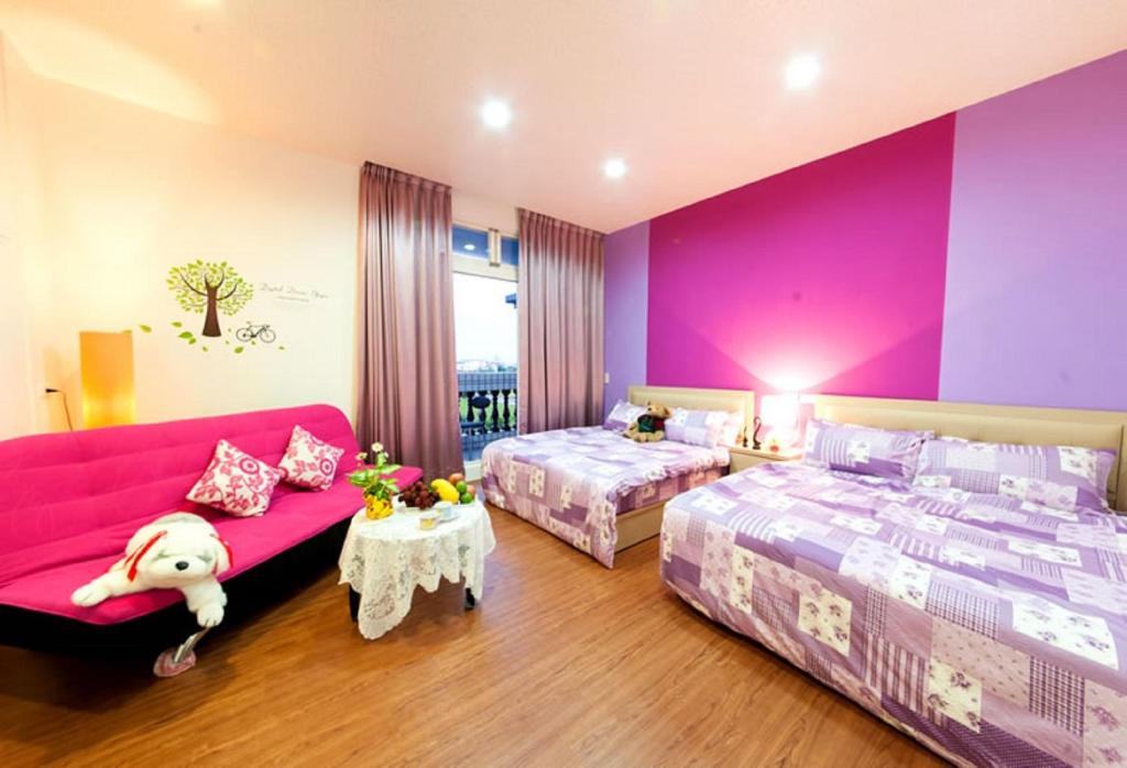 五结自由天地民宿的一间卧室设有两张床和粉红色的墙壁