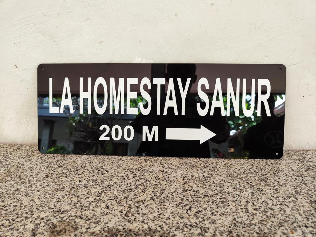 沙努尔LA Homestay sanur的箭头表示房屋稳定标志的标志