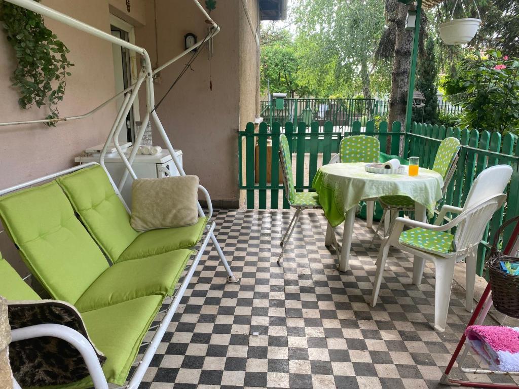韦切什Grany's Retro Guesthouse near Budapest AirPort的天井配有绿色沙发和桌子