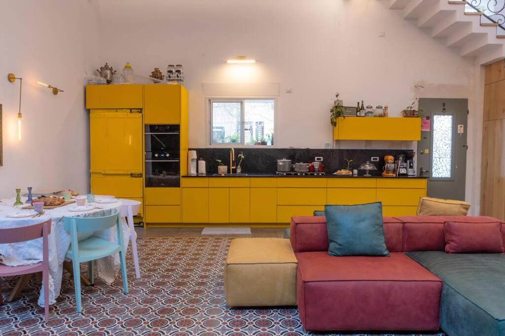 特拉维夫Tel Aviv Center Seaside Villa with a Pool & Rooftop的带沙发的客厅和带黄色橱柜的厨房