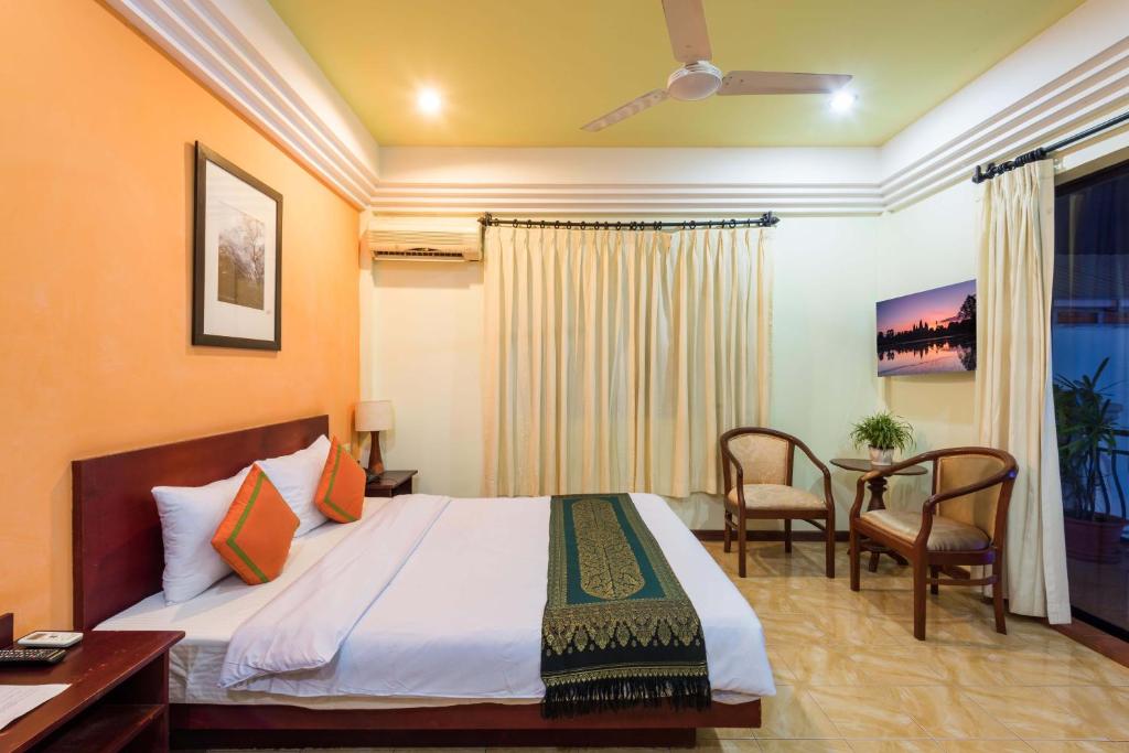 暹粒Sihariddh BnB Villa的酒店客房带一张床、一张桌子和椅子