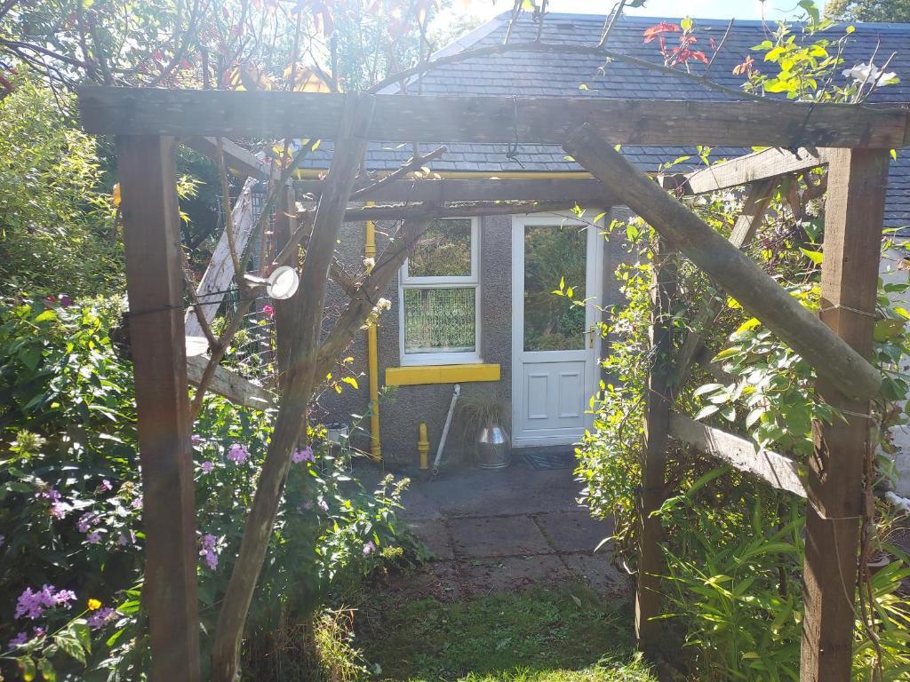 克里敦BARHOLM CROFT Holiday Cottage的花园内带门的木凉亭