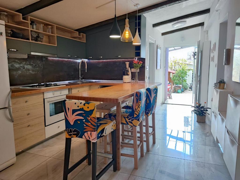 扎达尔KiMano Apartmans的厨房配有木桌和凳子