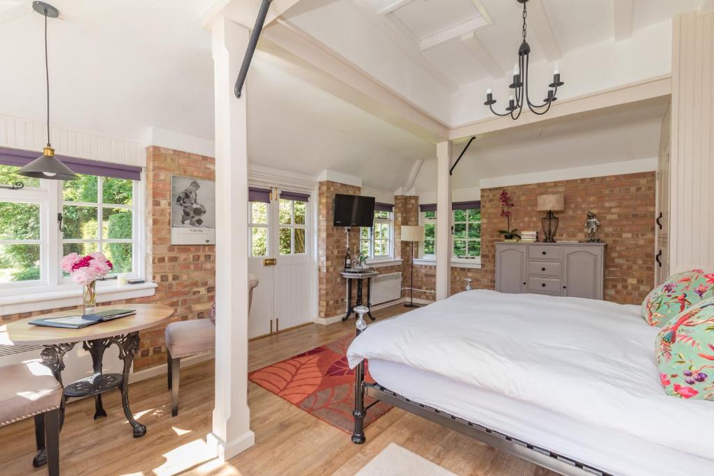 HurstpierpointOld Mill Lodge by Huluki Sussex Stays的一间卧室配有一张床、一张桌子和一张桌子