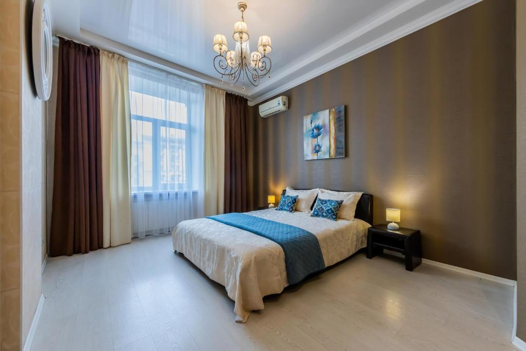 基辅2к квартира із видом на Хрещатик的一间卧室配有一张大床和一个吊灯。