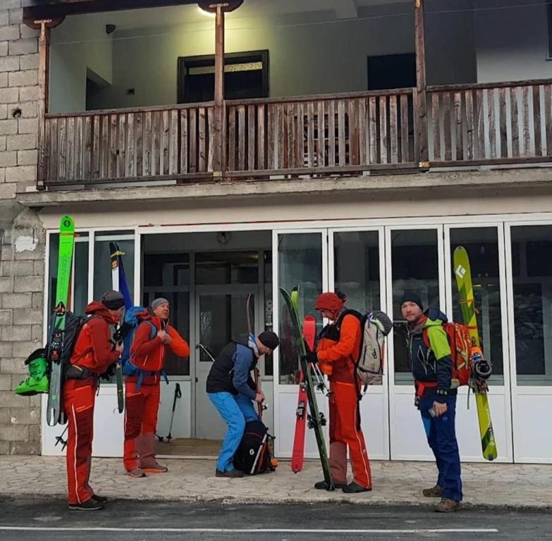 CerenGuest House Korabi的一群人站在一座滑雪板建筑外面
