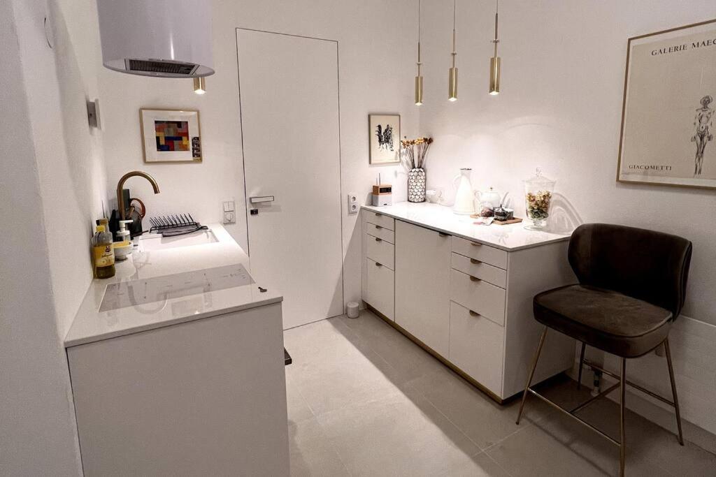 林茨Exclusive apartement in historic center的白色的厨房配有椅子和柜台