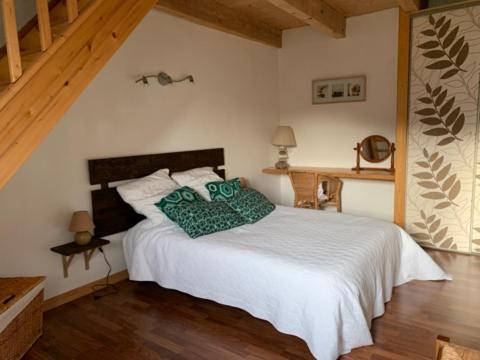 MadicLogis du lac à Madic的卧室配有带绿色枕头的白色床