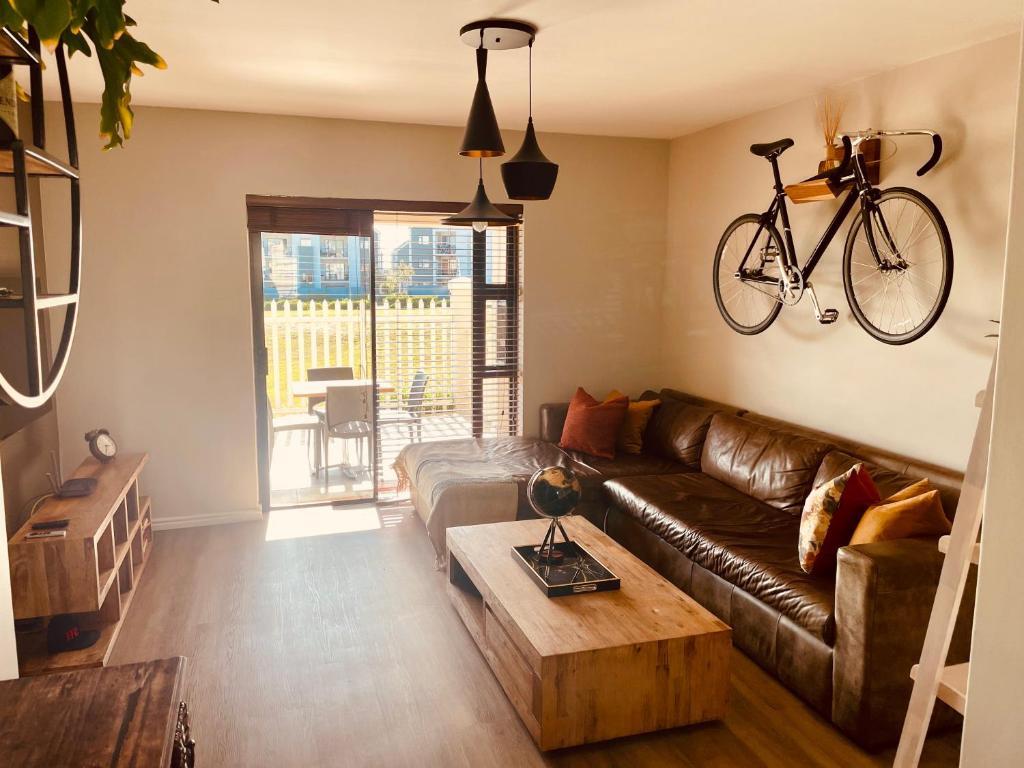 开普敦Mo's Explorer Cape Town Vacation Apartment的客厅配有沙发,墙上有自行车