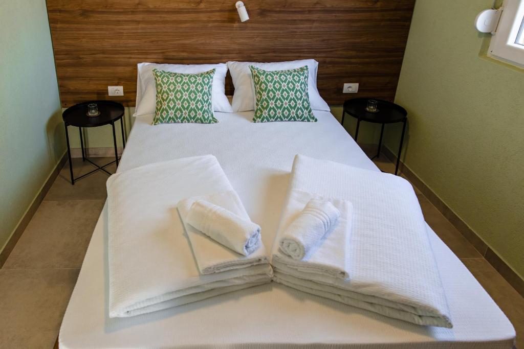 克拉列沃Đerdan Garden apartments的白色的床,上面有毛巾