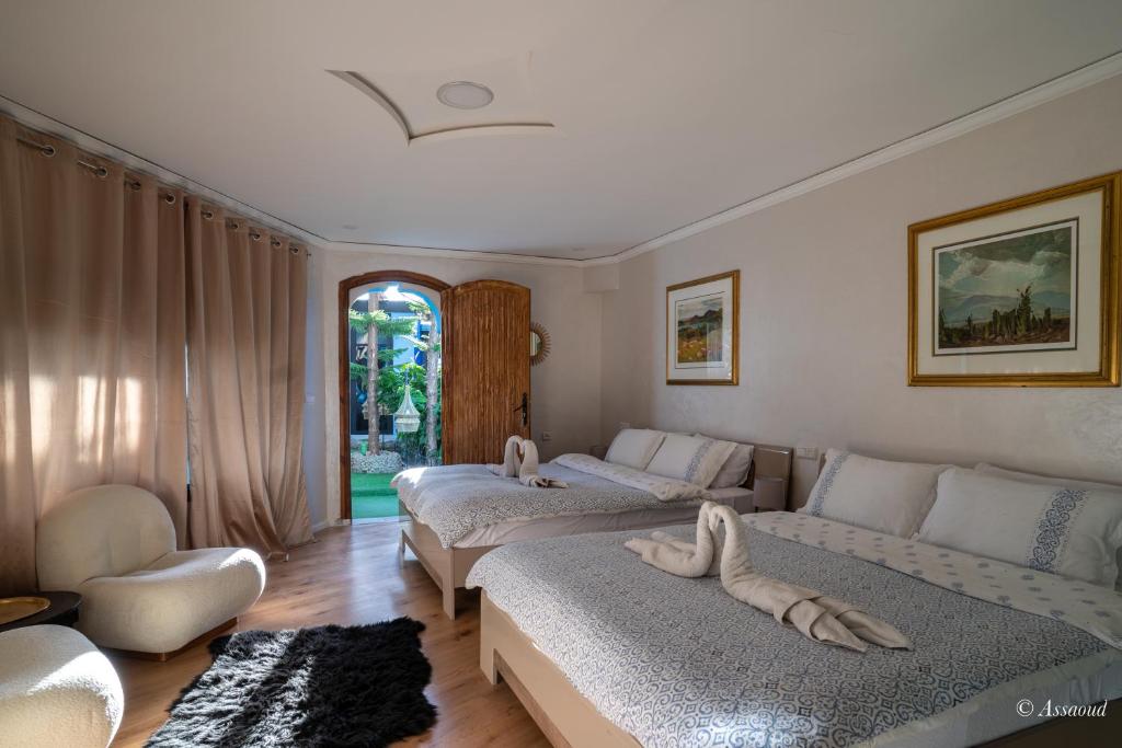 舍夫沙万Hôtel ZIRYAB的酒店客房,设有两张床和一张沙发