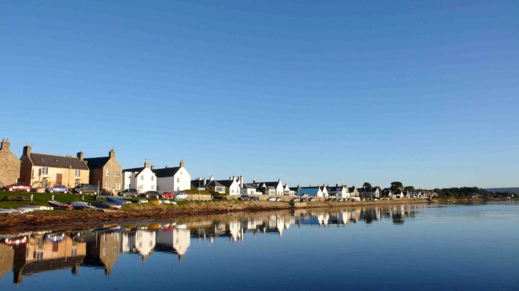 福里斯Driftwood Cottage, Findhorn Village的水边的一排房子