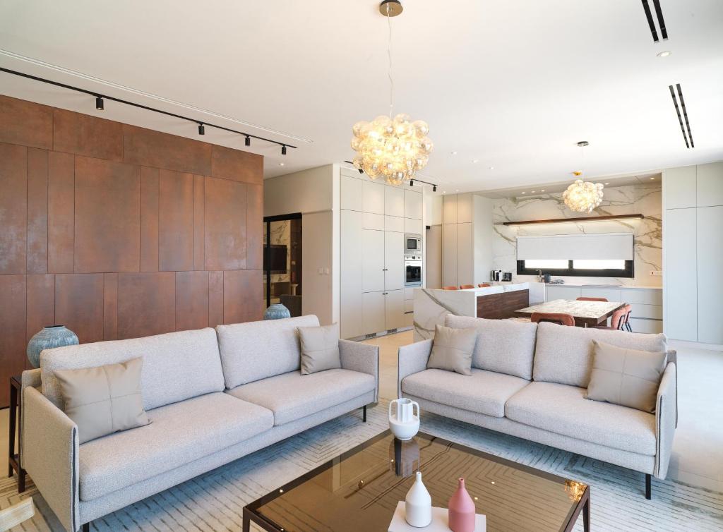 拉纳卡LIV Mackenzie Beach Suites Larnaca ADULTS ONLY的客厅配有两张沙发和一张桌子