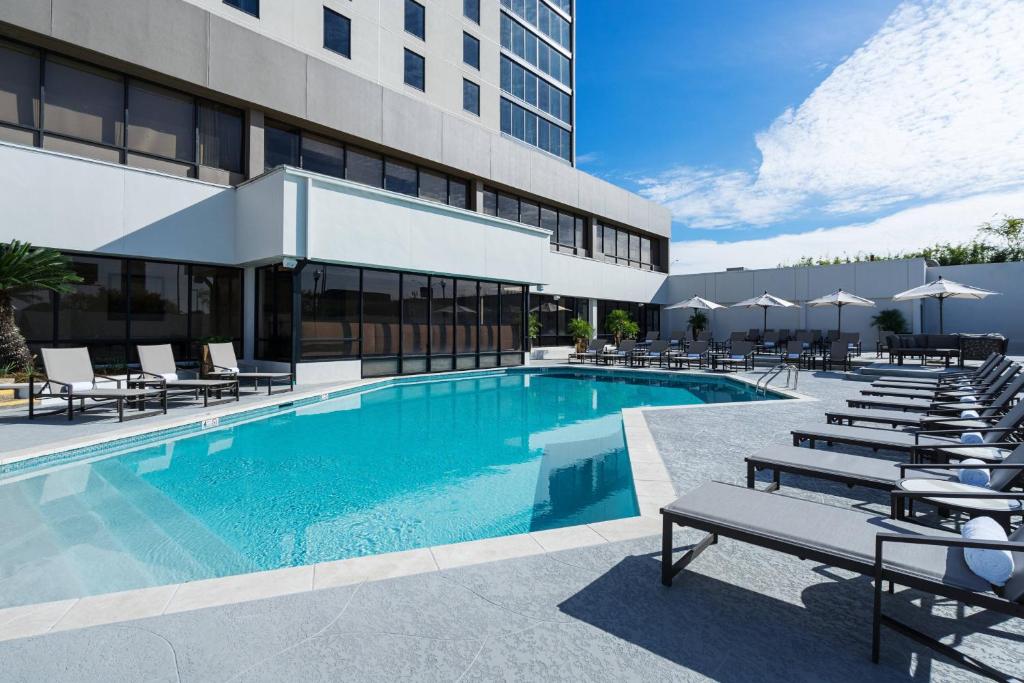 巴吞鲁日巴顿鲁日万豪酒店的一座带躺椅的游泳池和一座建筑
