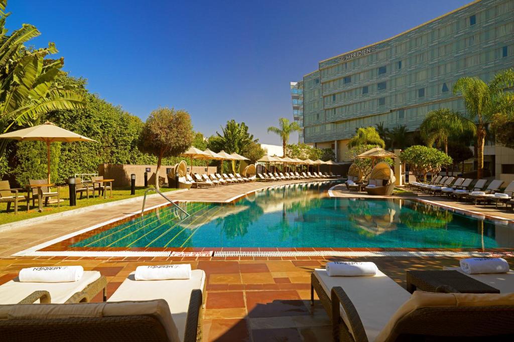 开罗乐蒙雷蒂恩开罗机场的一个带躺椅的游泳池和一间酒店