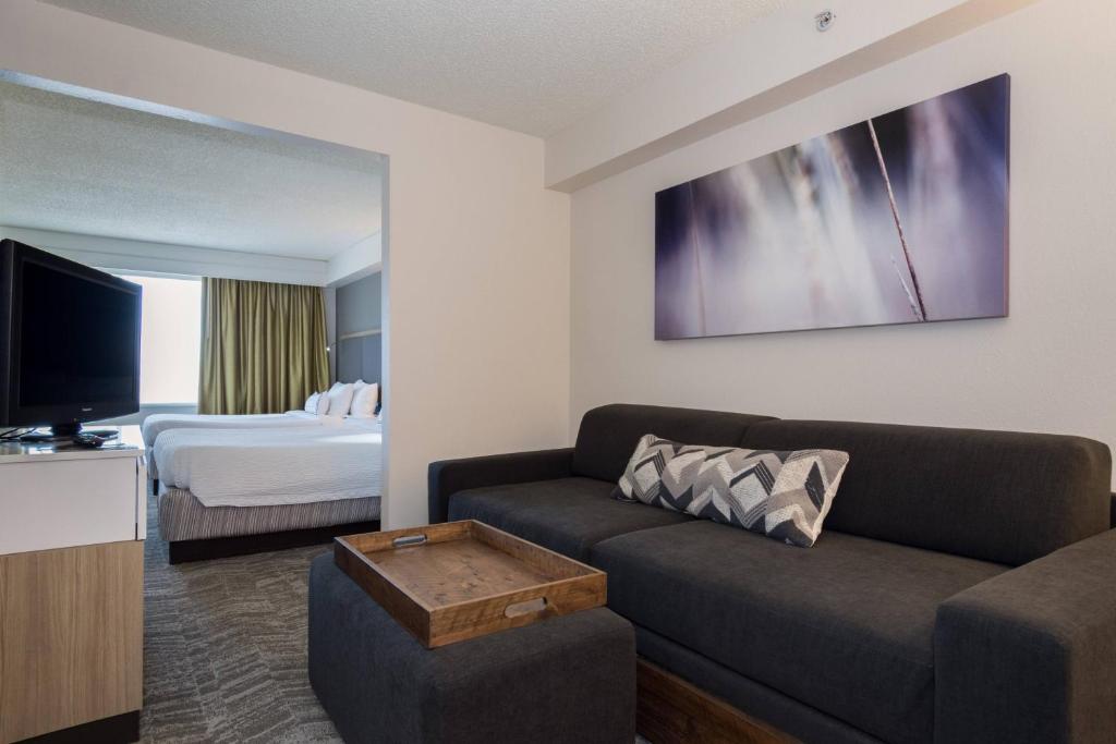 康科德夏洛特/康科德米尔斯赛道万豪春季山丘套房酒店的客厅配有沙发和1张床