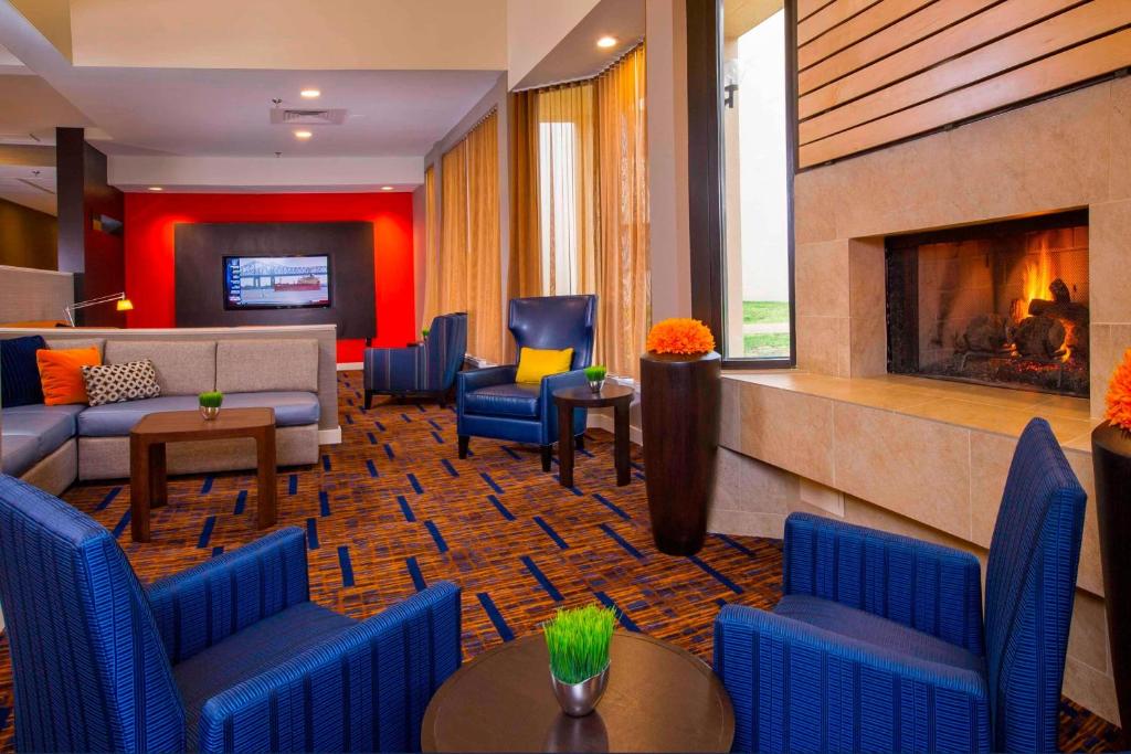 弗吉尼亚海滩维珍利亚诺福克海滩万怡酒店的酒店大堂设有蓝色椅子和壁炉