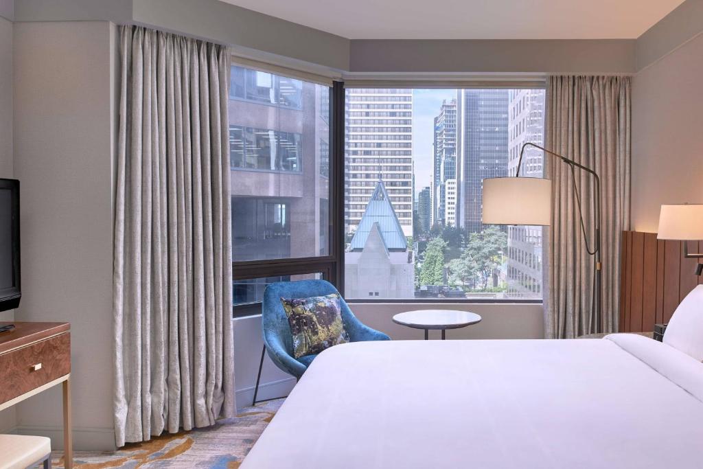 温哥华温哥华大都会饭店的酒店客房设有一张床和一个大窗户
