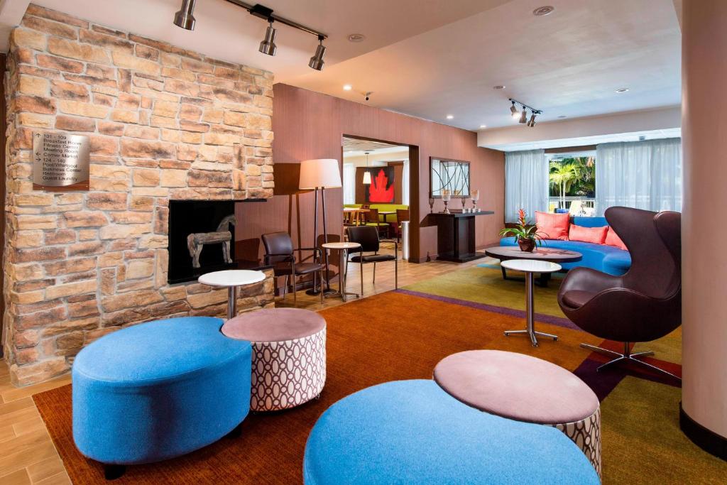迈尔斯堡麦尔兹堡开普科勒尔万豪费尔菲尔德客栈的客厅设有石制壁炉和蓝色家具。