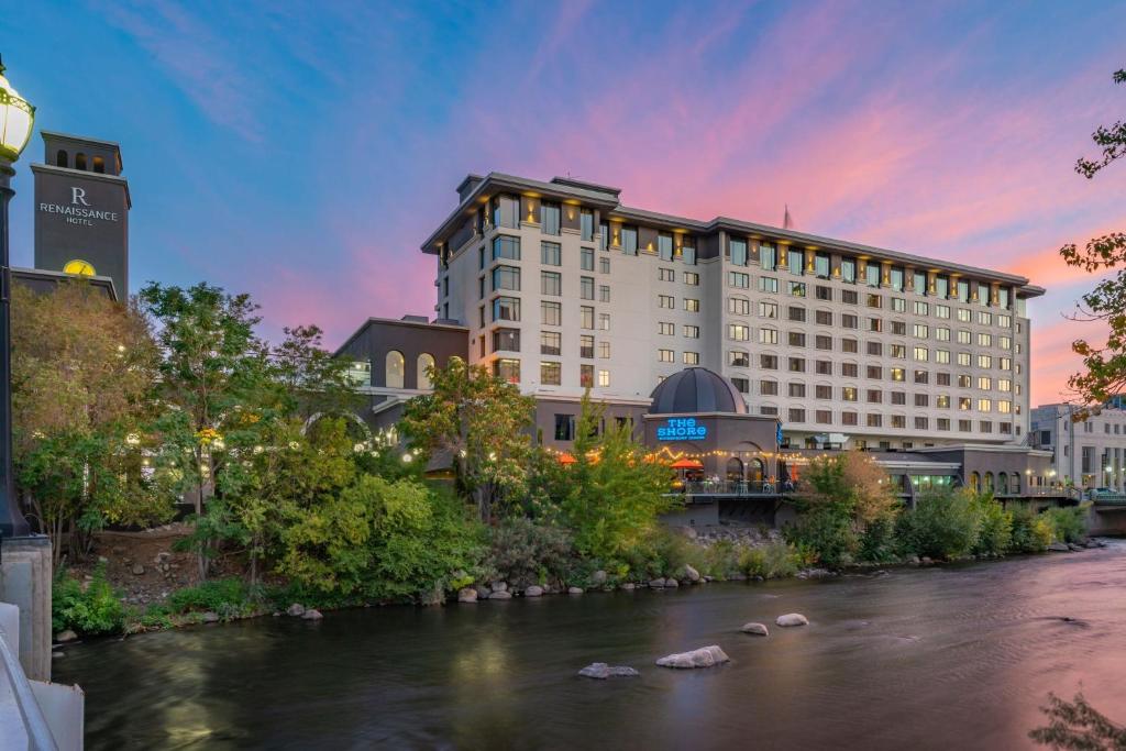 里诺Renaissance Reno Downtown Hotel & Spa的一座建筑前有河流的酒店