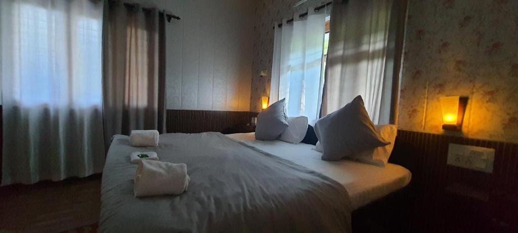 奈尼塔尔Karthik Resorts, Jeolikote Nainital的卧室配有一张大白色床和窗户