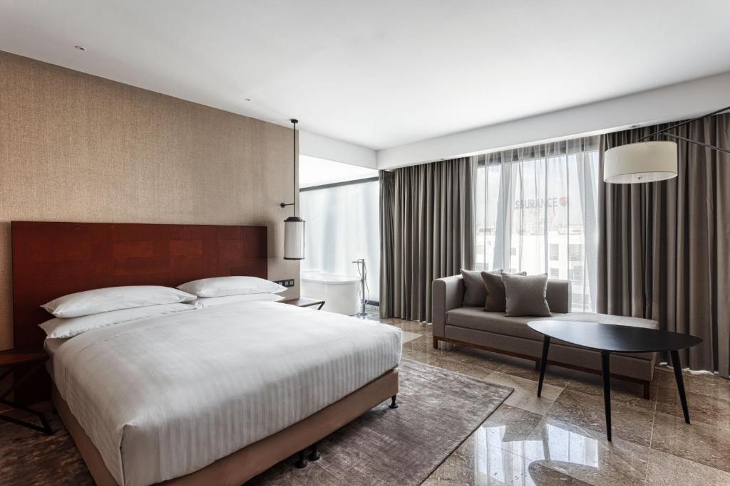 突尼斯Tunis Marriott Hotel的一间卧室配有一张大床和一张沙发