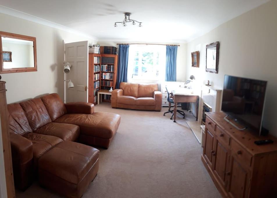 WelburnEntire house, Crambeck,Welburn, near Castle Howard的客厅配有棕色真皮沙发和书桌