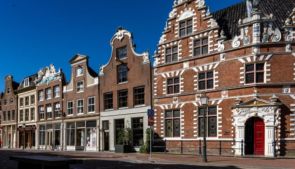 霍恩De Ginkgo in het hart van Hoorn的街道上一座红门的大型砖砌建筑