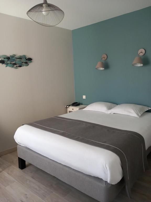 佩罗斯-吉雷克隐居旅舍的一间卧室设有一张蓝色墙壁的大床