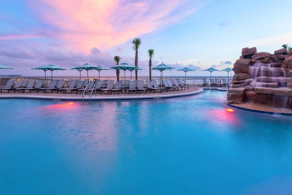 巴拿马城海滩SpringHill Suites by Marriott Panama City Beach Beachfront的海滩上带椅子和遮阳伞的游泳池
