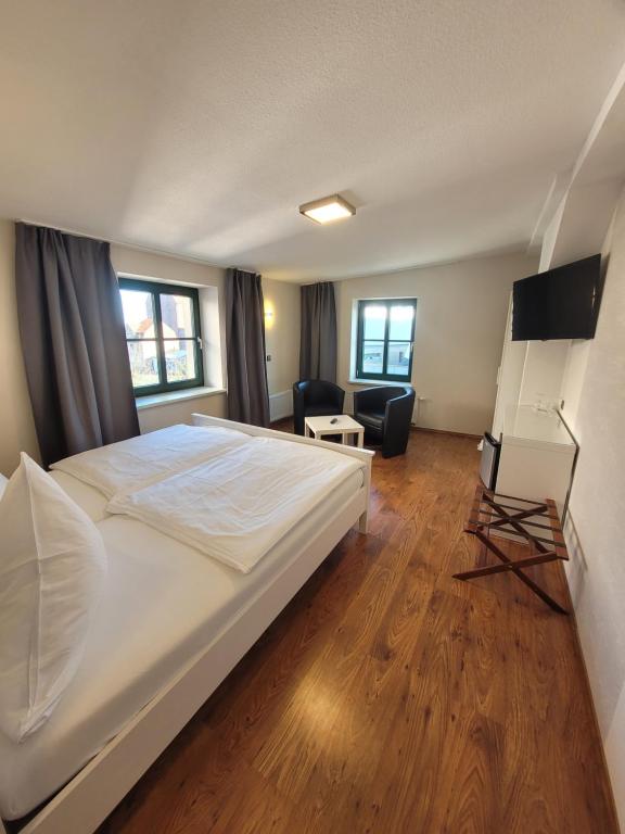 施特拉尔松德欧泽内姆酒店的一间卧室配有一张床、一张桌子和一把椅子