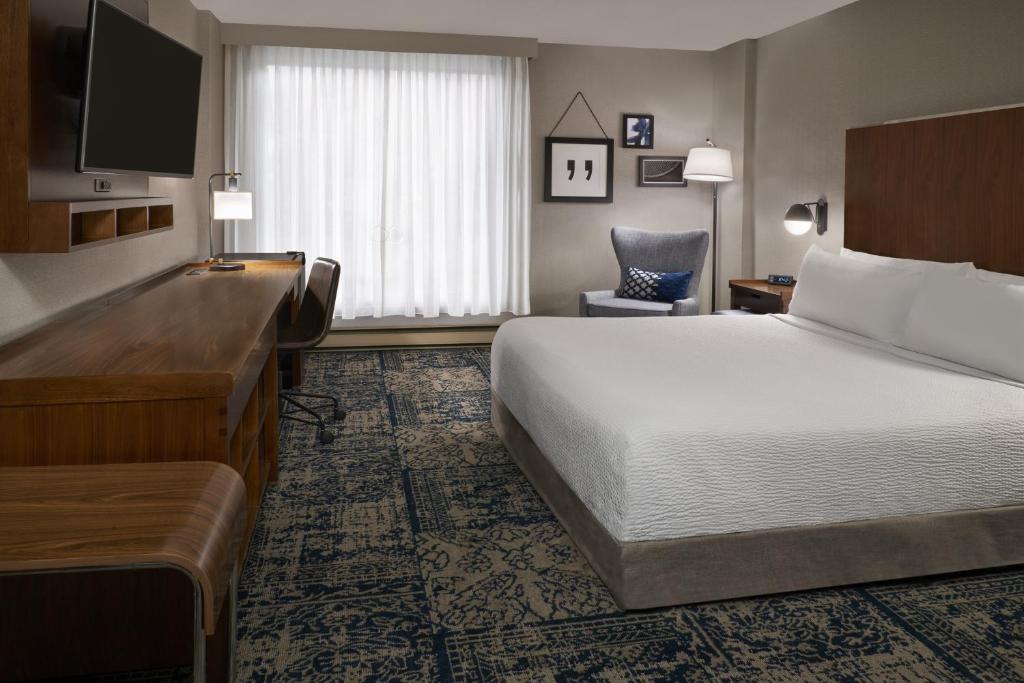 加蒂诺Four Points by Sheraton Hotel & Conference Centre Gatineau-Ottawa的配有一张床和一张书桌的酒店客房