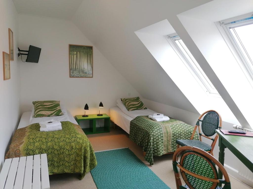 马斯塔尔Femmasteren Hotel & Hostel的阁楼卧室配有两张床和长凳