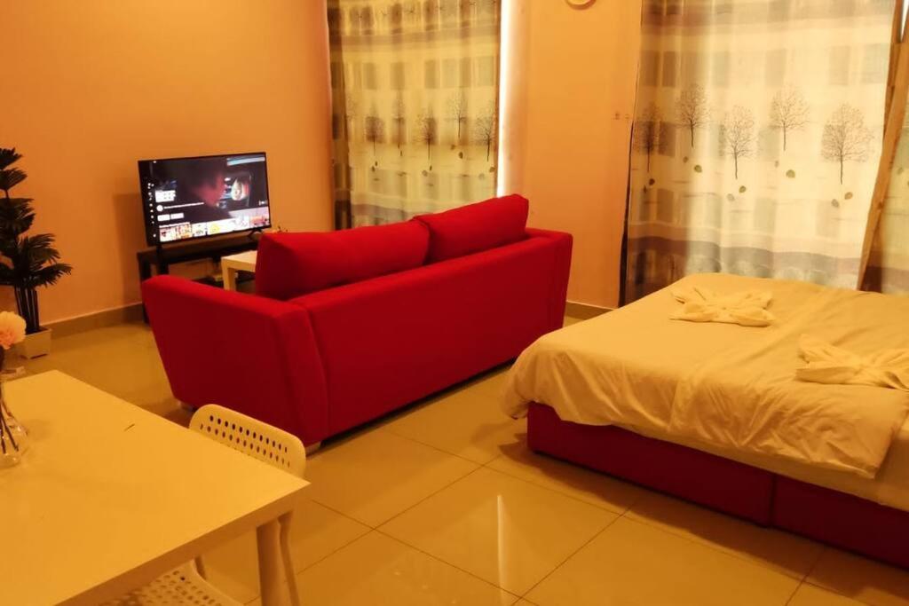 塞贝维CQ1305-Selfcheckin-Netflix-Wifi-Parking-Cyberjaya, Cybersquare Soho,2012的客厅配有红色的沙发和床。