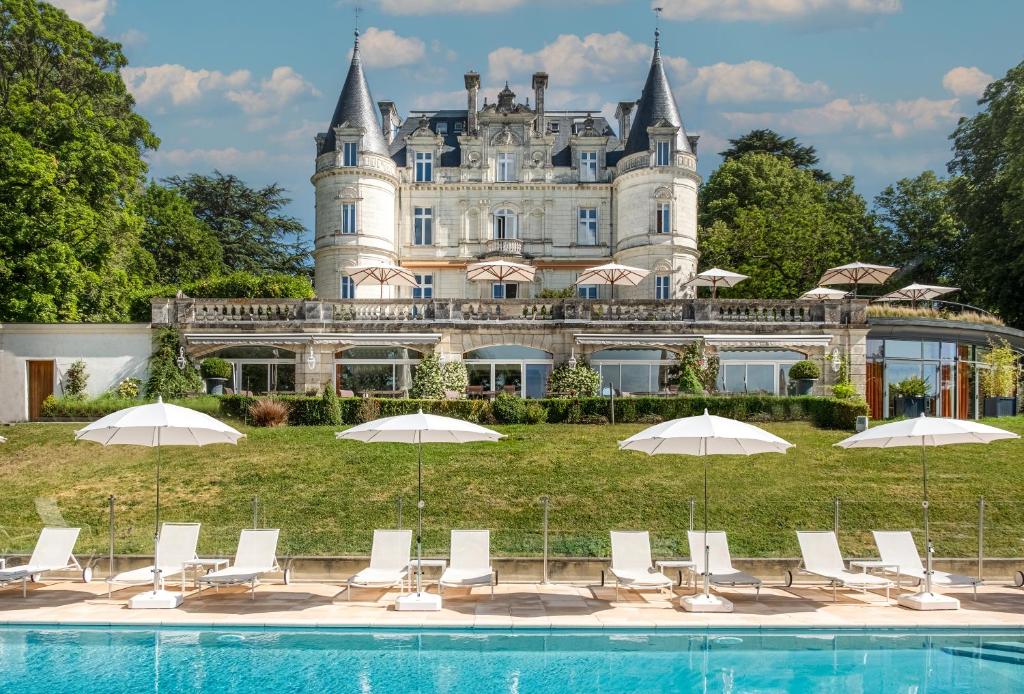 蒙巴宗Domaine de la Tortinière的城堡前的游泳池,配有椅子和遮阳伞