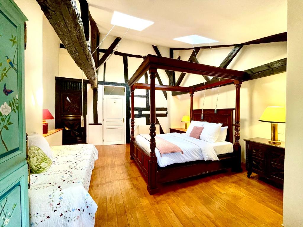 贝尔热拉克Le Logis Plantagenêt的一间卧室配有四柱床和沙发