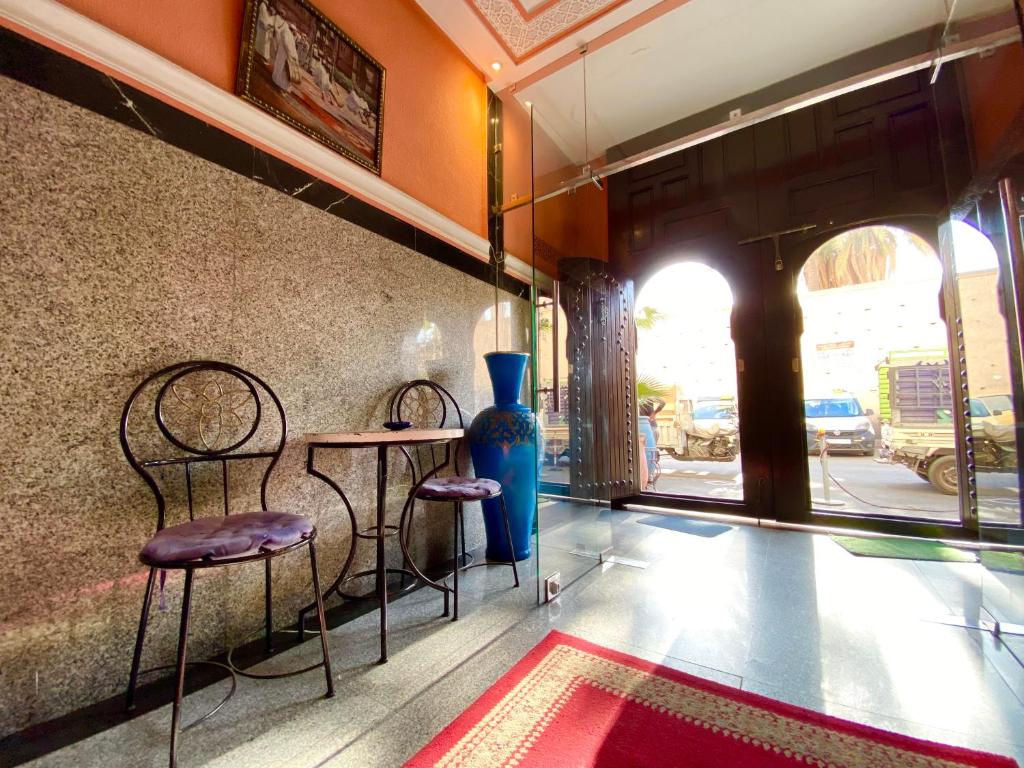 马拉喀什纳吉斯酒店的一间设有两把椅子、一张桌子和一个花瓶的房间