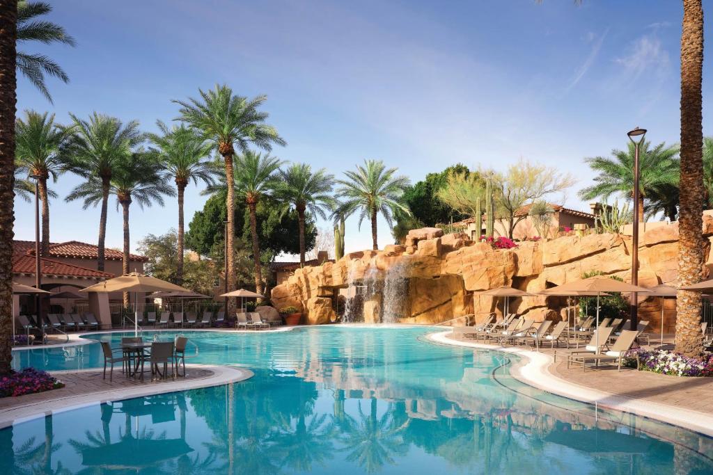 斯科茨Sheraton Desert Oasis Villas, Scottsdale的一座拥有瀑布和棕榈树的度假村的游泳池