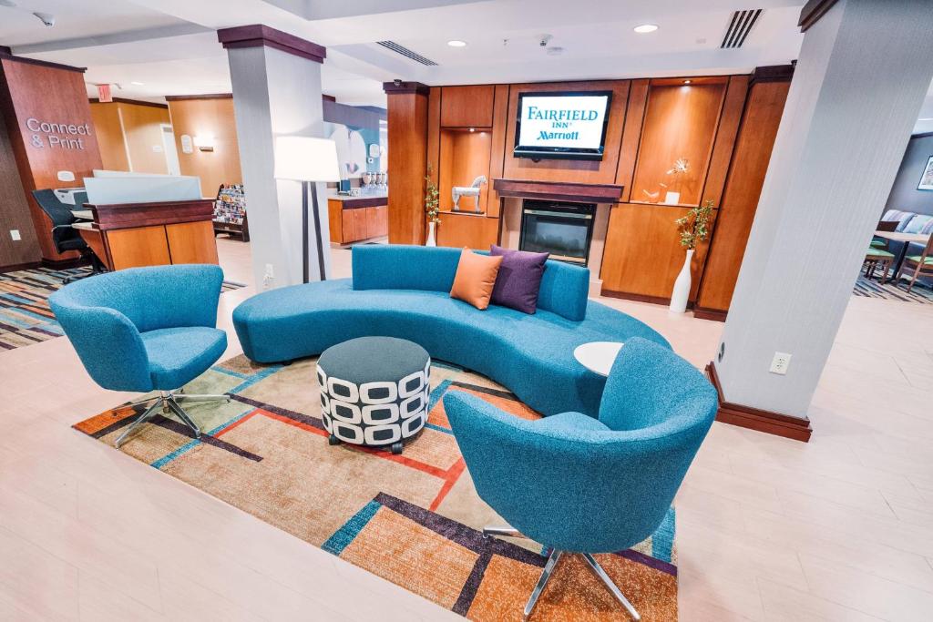 梅德福Fairfield by Marriott Medford Long Island的客厅配有蓝色的沙发和两把椅子