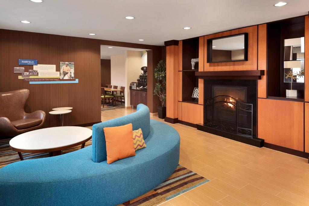 布卢明顿明尼阿波利斯布卢明顿/美国商场费尔菲尔德客栈酒店的客厅设有蓝色的沙发和壁炉